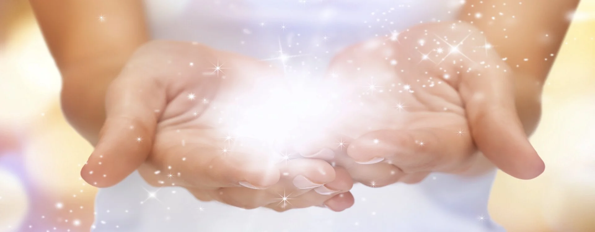 Deux mains remplies de scintillements et multiples lumières — bonheur, abondance et gratitude de la Conscience infinie