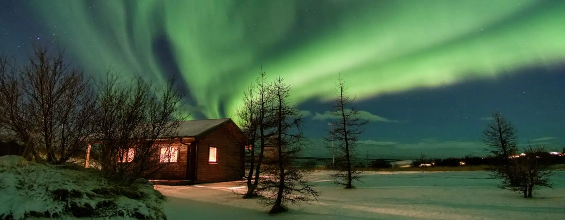Maison sous le ciel d'aurore boréale illustrant la nuit où l'on n'est plus seul au monde — transcendance du « Quelque chose et moi » de Gérard Lenorman